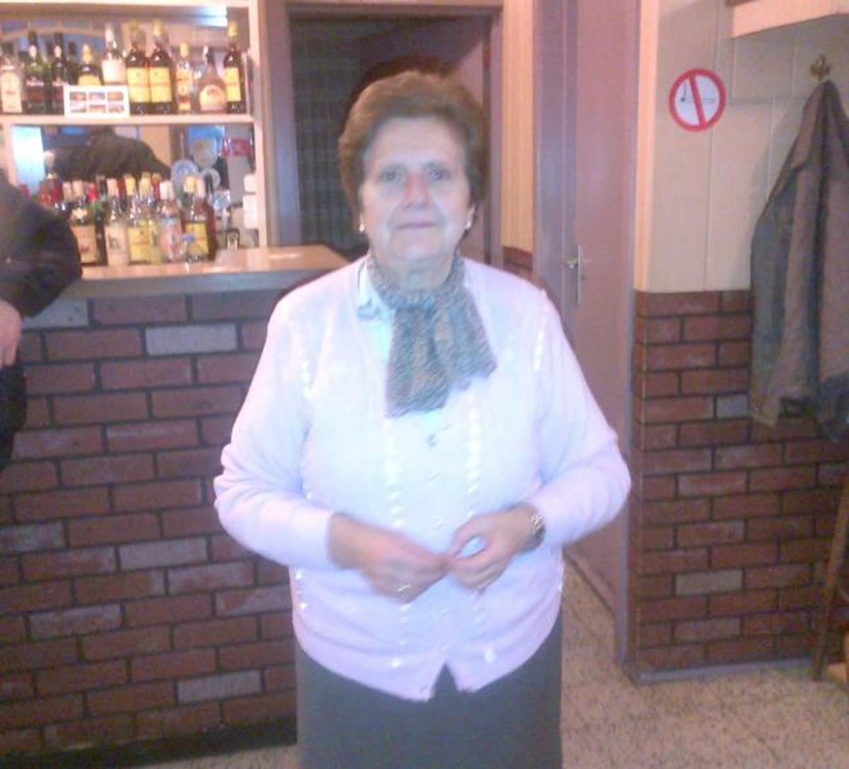 Adelina Cueto, en el interior del bar y ante su entrada.