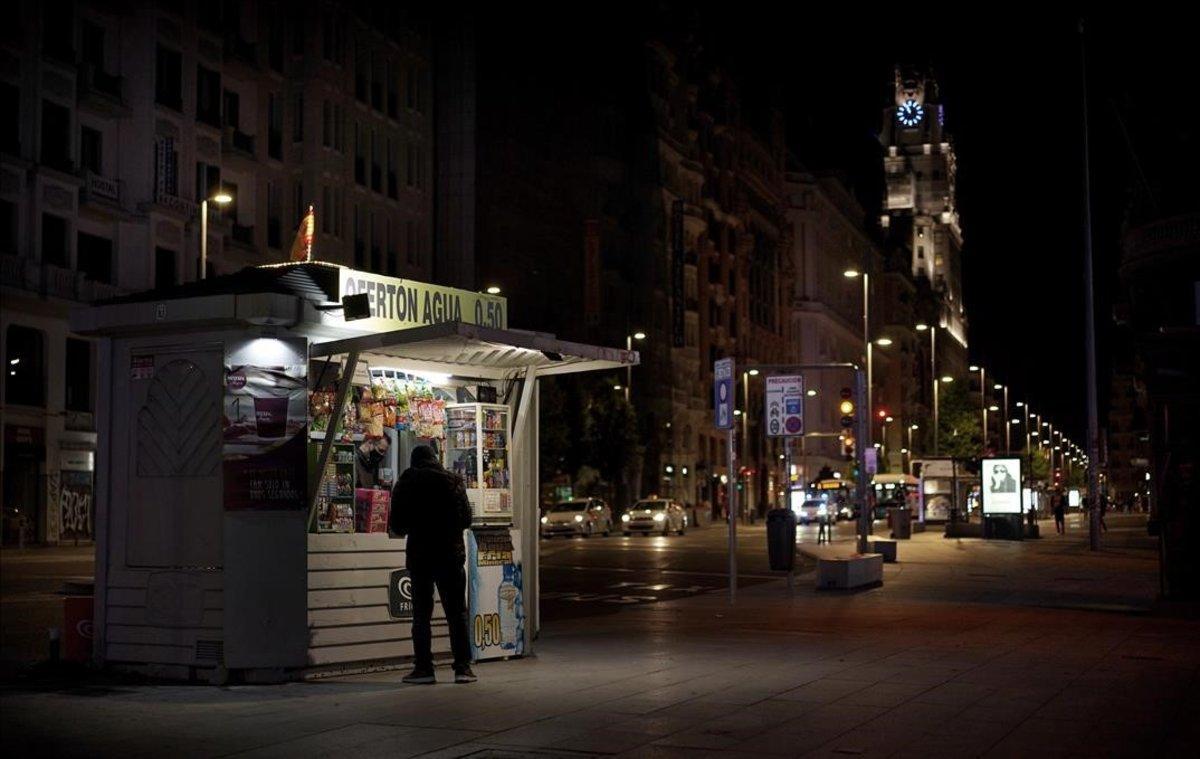 Un quiosco abierto en Madrid, de noche.