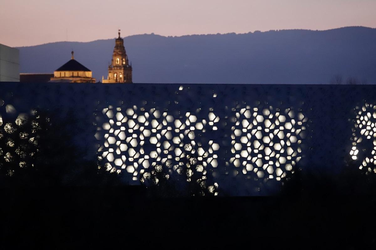 Fachada iluminada del C3A de Córdoba, con la torre de la Catedral al fondo
