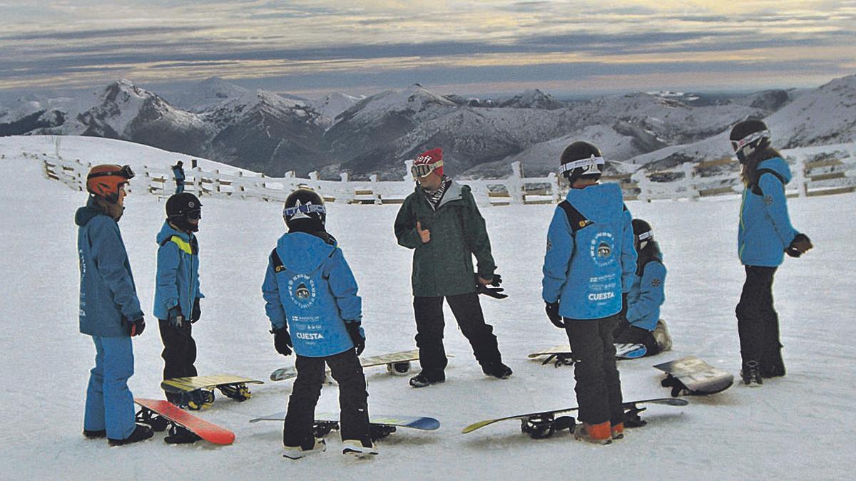 Un monitor da clases de snowboard a unos niños de un club en Valgrande-Pajares. | LNE