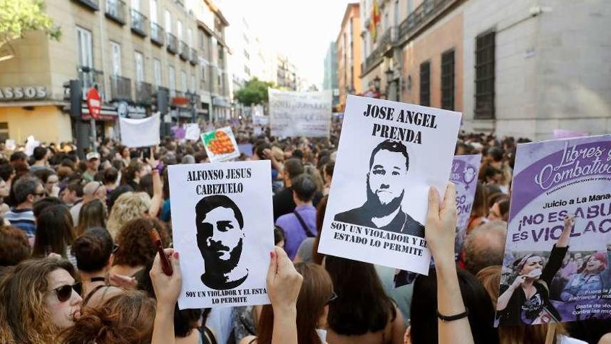 Varias mujeres portan carteles con la cara de los miembros de &#039;La Manada&#039; en una protesta. // Efe