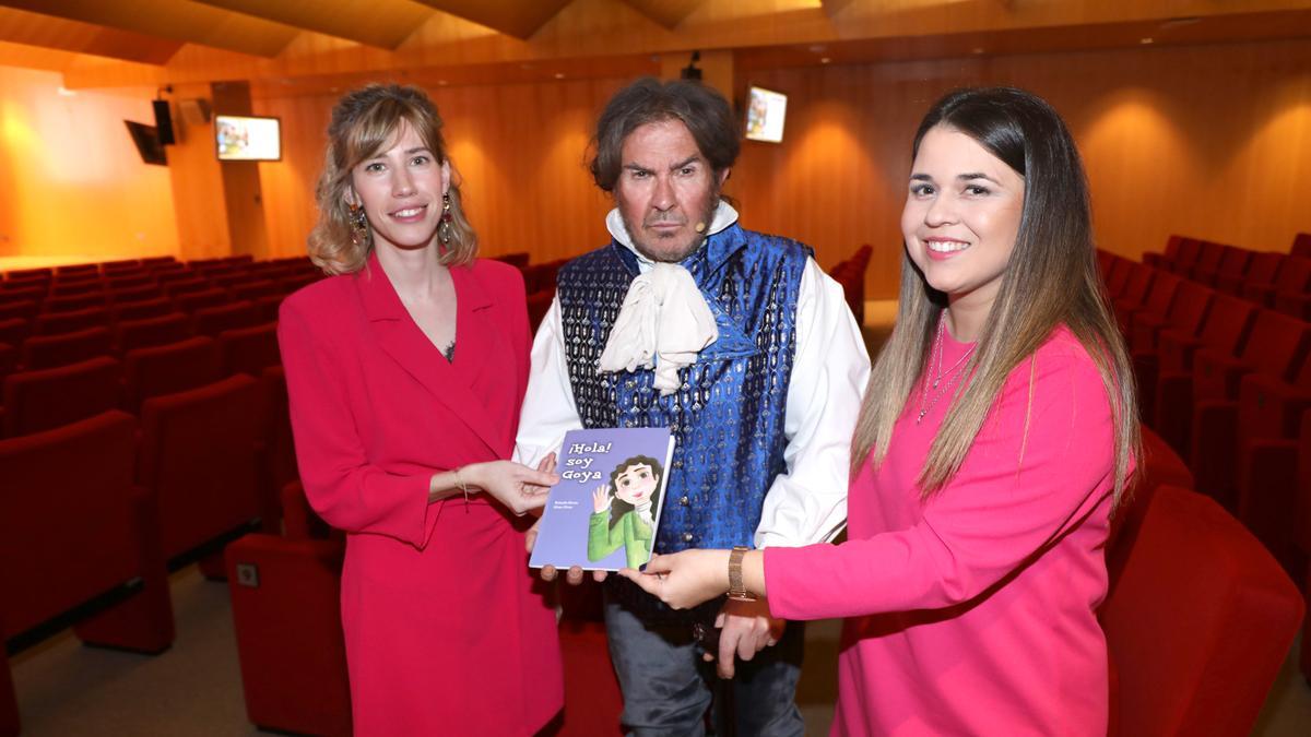 Elena Pérez, Francisco de Goya y Brianda Buesa, con el libro, en el Patio de la Infanta de Zaragoza.