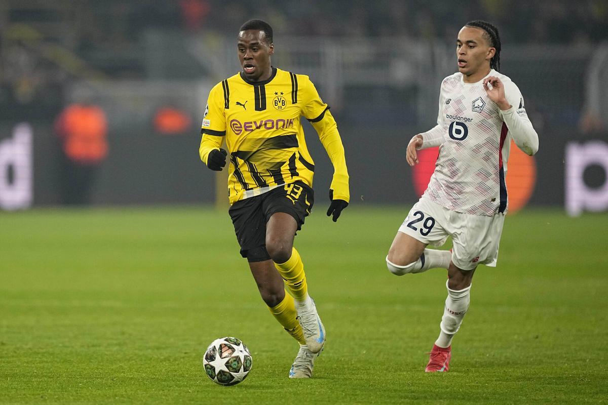 Dortmund's Jamie Bynoe-Gittens, left, controls the ball as Lille's Ethan Mbappe runs behind him during the Champions League round of 16 first leg soccer, between Borussia Dortmund and Lille at the Signa-Iduna Park in Dortmund, Germany, Tuesday, March 4, 2025. (AP Photo/Martin Meissner)
