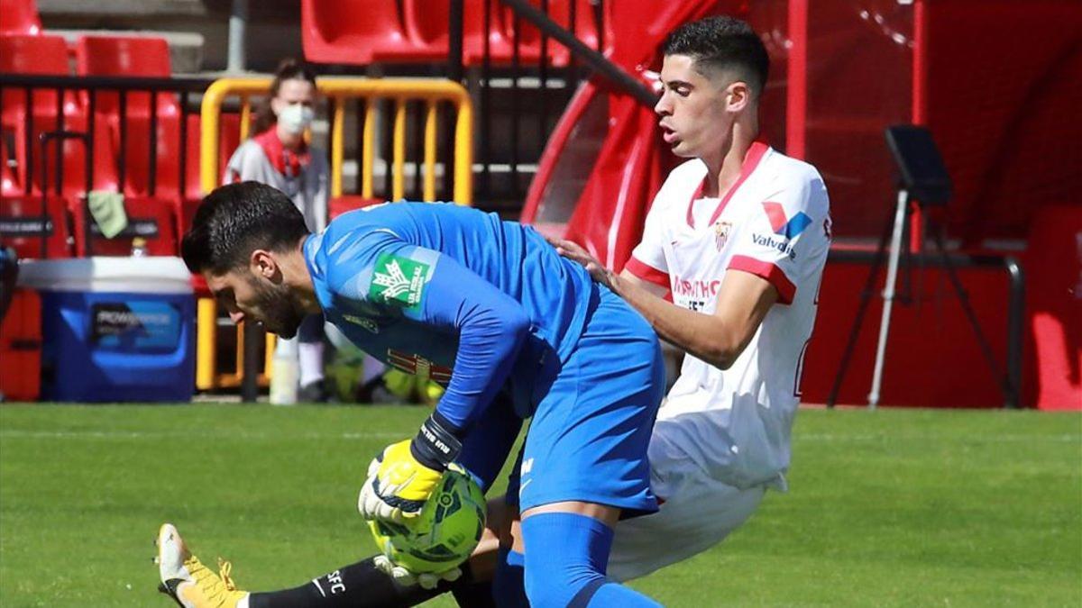 El jugador del Sevilla Carlos Fernández presiona al portero del Granada Rui Silva, durante el partido de la sexta jornada de Liga de Primera División