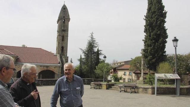 Vecinos conversan en el entorno de la iglesia y de la torre de Mombuey. | A. SAAVEDRA