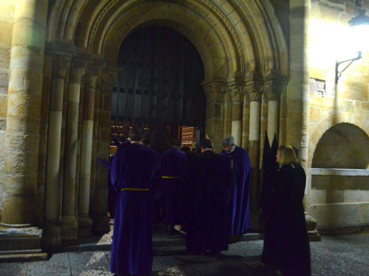Varios cofrades entrando en la iglesia de San Juan. | E. P.