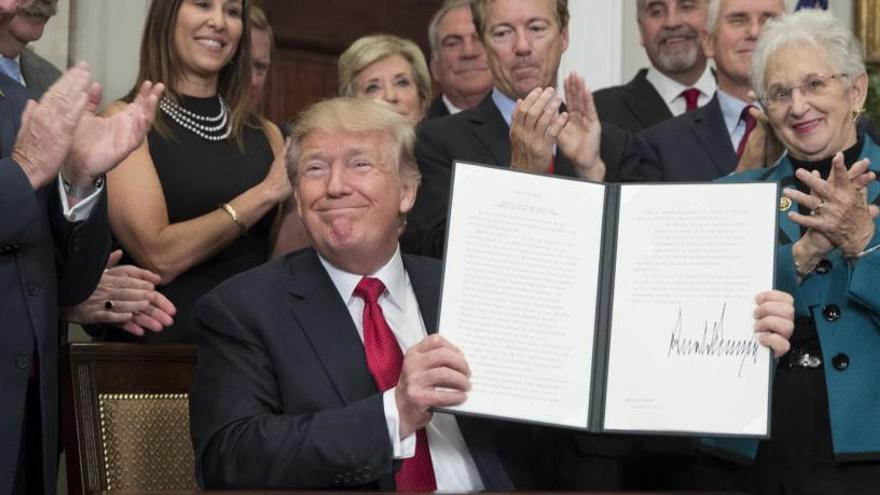 Donald Trump posa tras firmar una orden ejecutiva.