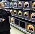 Una mujer mira monitores en una tienda de televisiones en San Petersburgo durante un discurso de Vladimir Putin