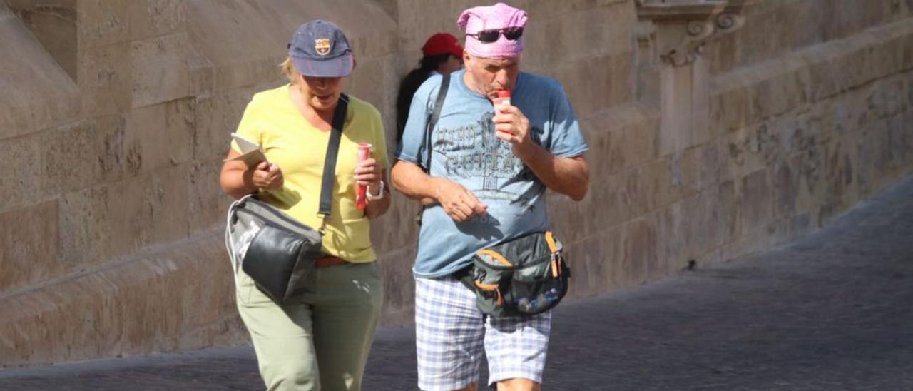 Dos solitarios turistas pasean por el entorno de la Mezquita.