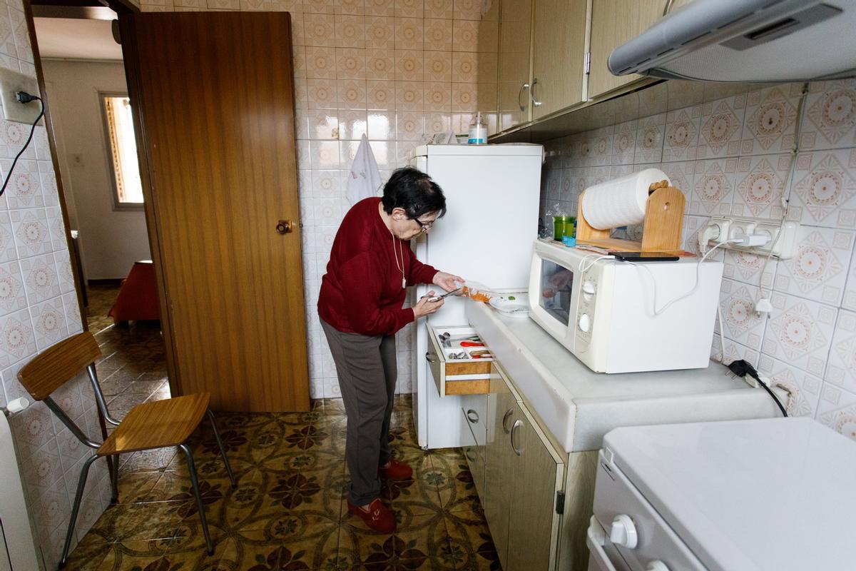 Antonia Torres, una vecina de 77 años de Sabadell, se calienta la comida precocinada que a diario le compra un asistente del SAD.