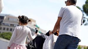 Un padre pasea con sus hijas por Madrid.