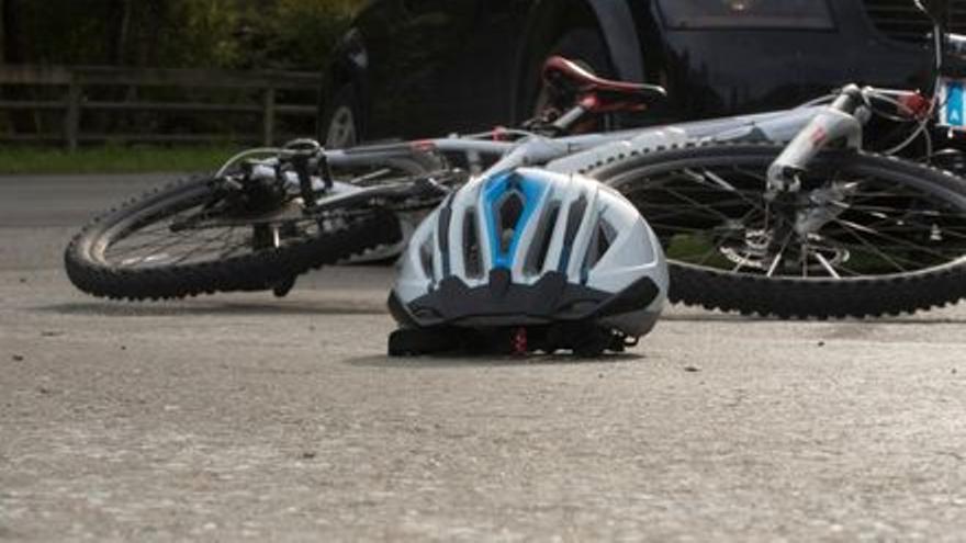 Una bicicleta y un casco sobre la calzada.