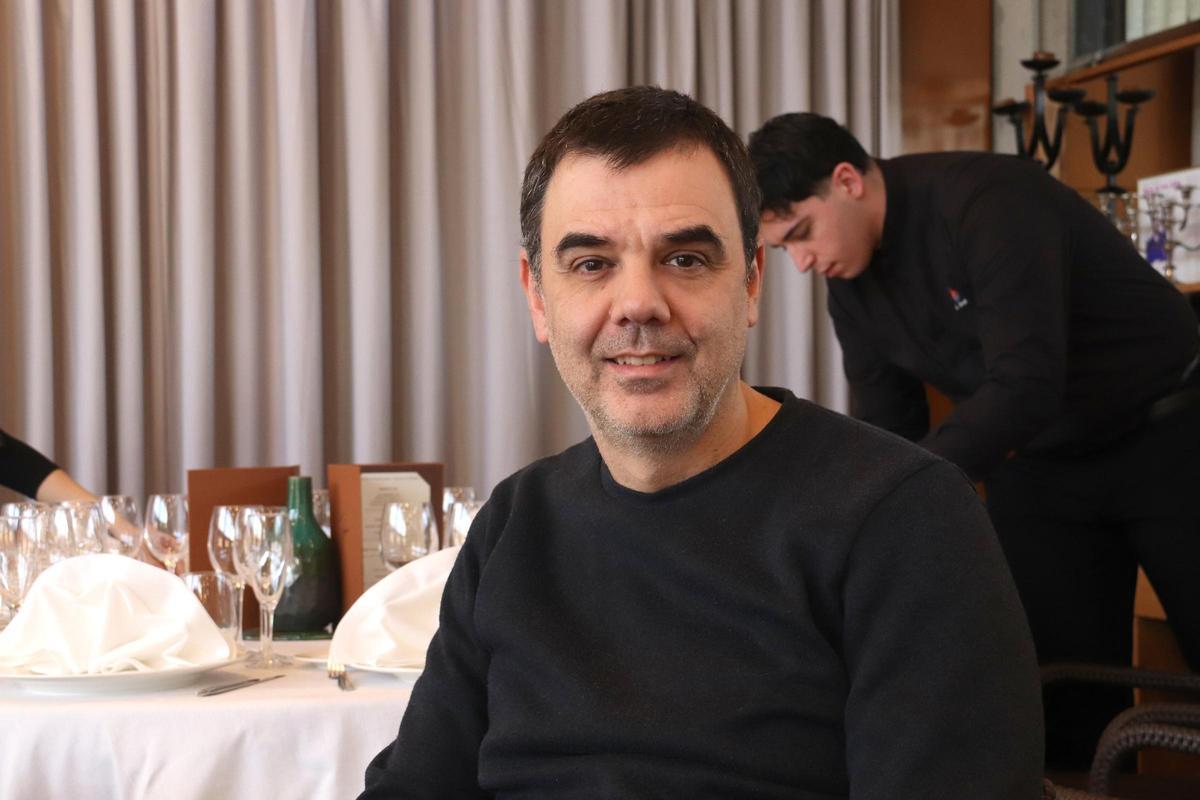 El director de l'Escola d'Hostaleria i Turisme de Girona, Jordi Garcia, en una taula mentre estudiants fan pràctiques de sala al fons