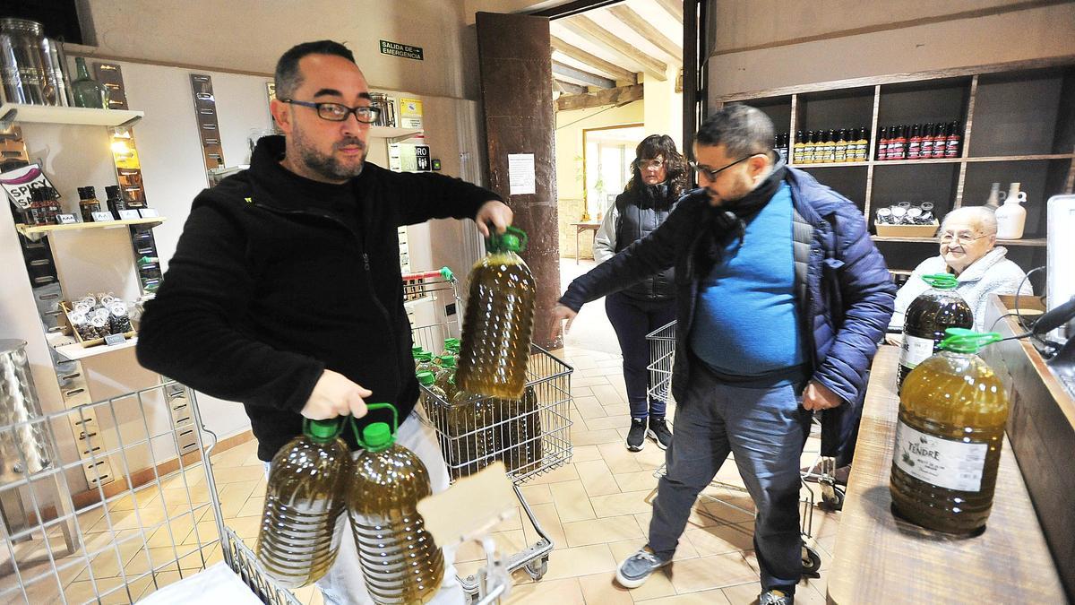 Usuarios cargan garrafas de aceite en la almazara El Tendre de Elche