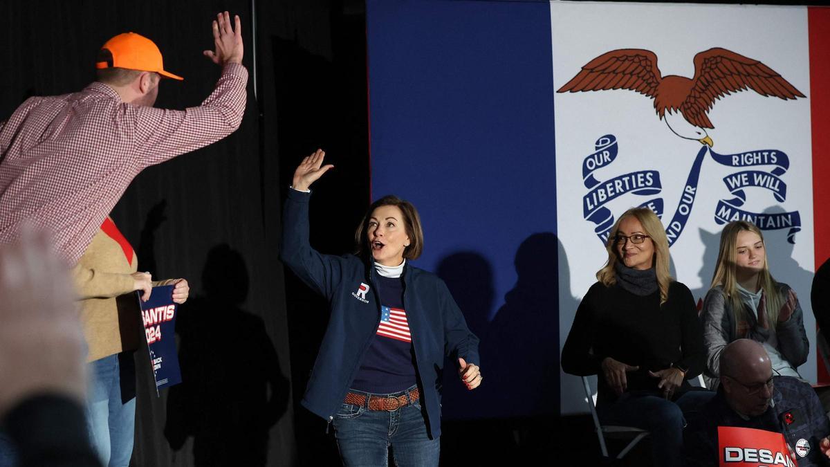 La gobernadora Kim Reynolds saluda a un partidario en un acto de campaña a favor del gobernador de Florida, Ron DeSantis, en Council Bluffs, Iowa.