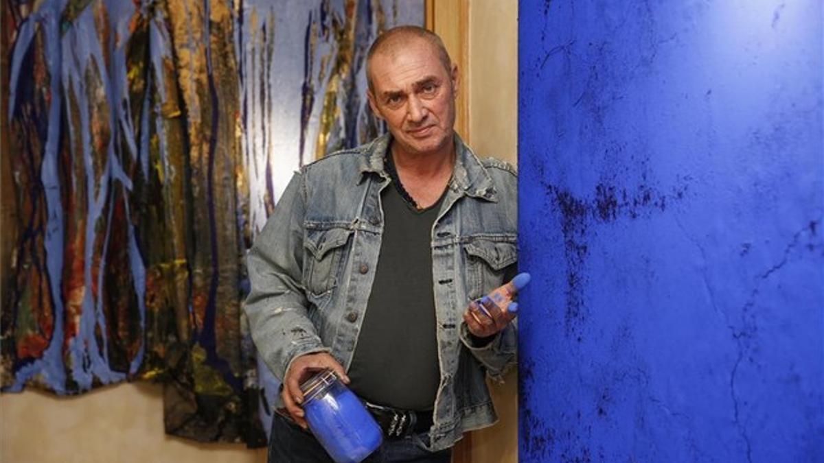 Philippe Pastor, en su piso del Eixample, con el bote de su preciado pigmento azul que usa en sus cuadros