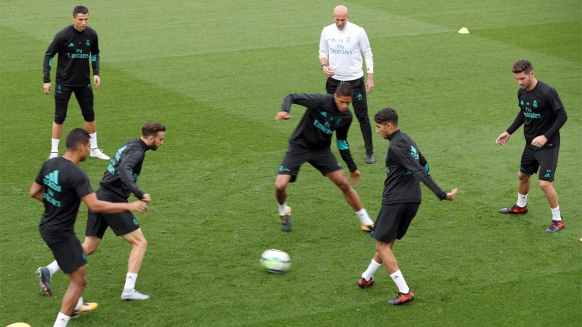 Zinedine Zidane (al fondo, de blanco) durante el entrenamiento de su equipo previo al partido contra el Espanyol