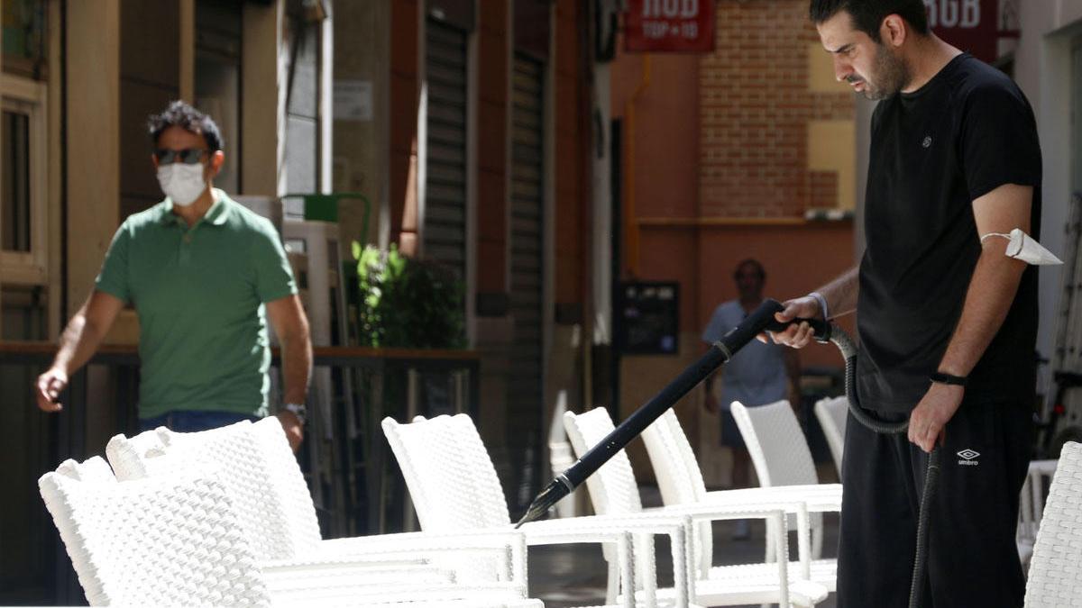 Un empleado desinfecta una terraza del Centro.