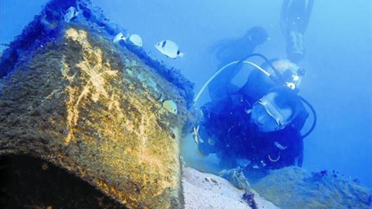 Un submarinista retira un contenedor de basuras hundido junto al espigón de la Mar Bella, en Barcelona, en noviembre del 2011.