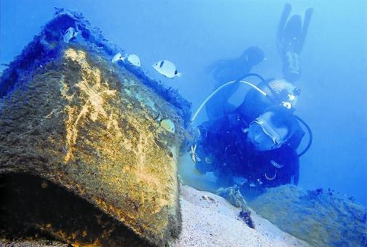 Un submarinista retira un contenidor d’escombraries enfonsat a prop de l’espigó de la Mar Bella, a Barcelona, el novembre del 2011.