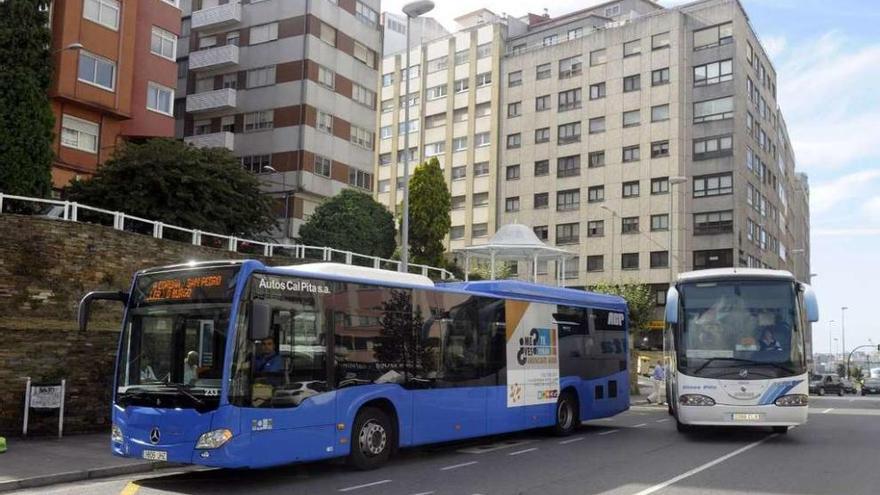 Buses metropolitanos en una parada en Os Castros.