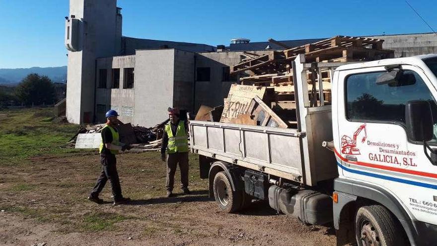 Empleados de la empresa adjudicataria del desescombro acotando la zona, ayer en Paramos. // DBM