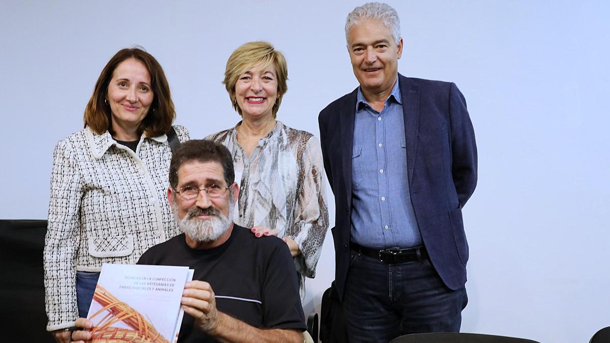 Julián Rodríguez muestra el libro durante la presentación junto a autoridades municipales.