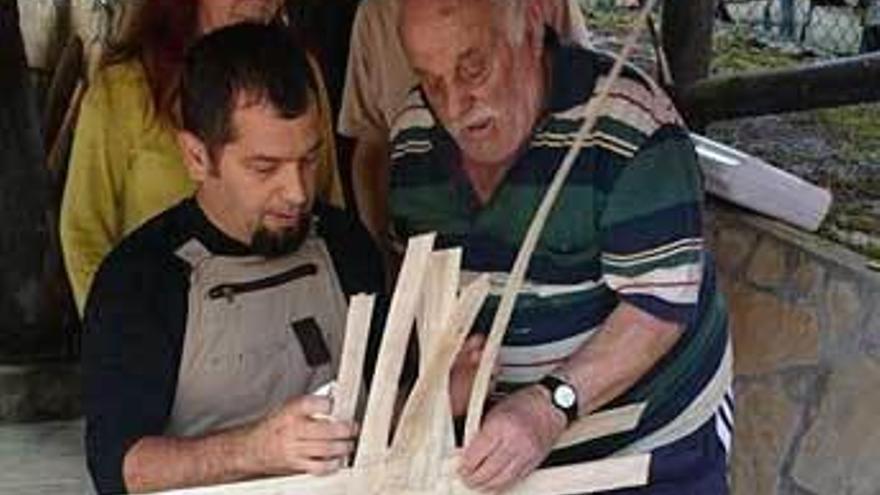En la imagen de la izquierda, Eladio Abaría, a la derecha, dando instrucciones. A la derecha, Pablo Fernández se afana en terminar un cesto.