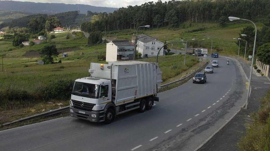 Un camión de basura circula por la carretera que une Pastoriza y Oseiro.