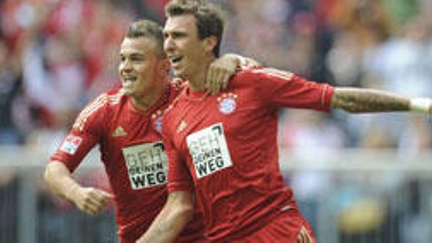 El jugador del Bayern Munich Mario Mandzukic (d) celebra su gol contra el FSV Mainz con su compañero Xherdan Shaqiri (i) durante su partido de la Bundesliga alemana jugado hoy domingo 15 de septiembre de 2012 en el Allianz Arena de Munich, Alemania.