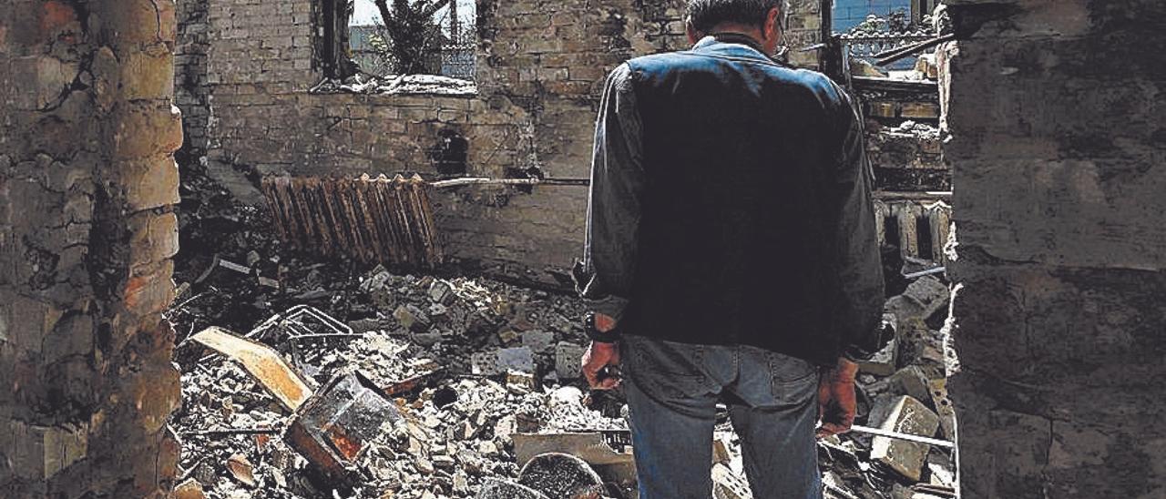Un vecino de Horenka, una localidad al norte de Kiev, observa los restos de los edificios destruidos por los ataques rusos. SERGEI SUPINSKY