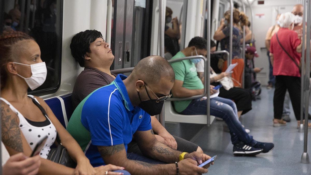 Pasajeros con y sin mascarilla en el interior de un vagón de metro en Barcelona