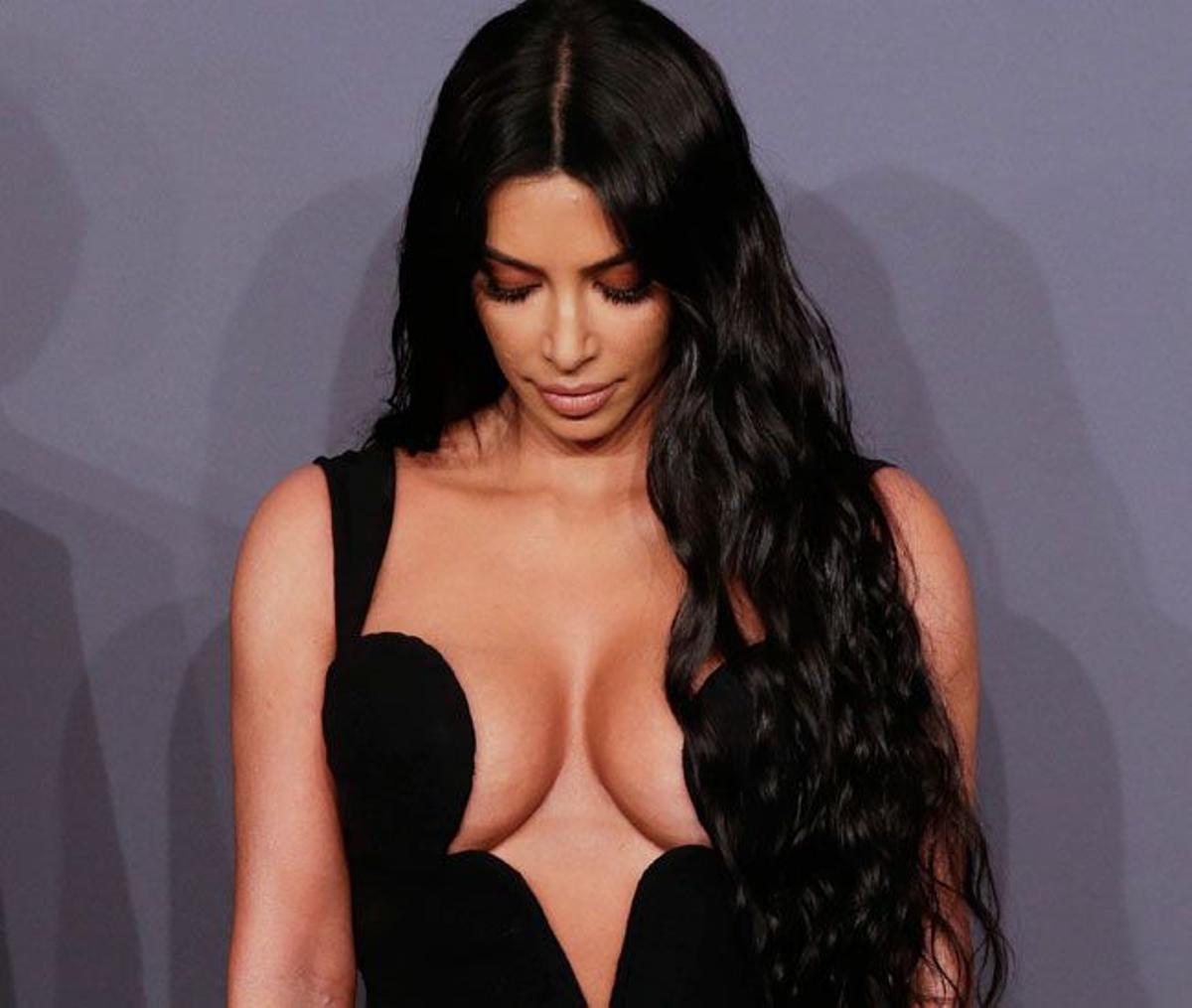 Kim Kardashian muy pendiente de su escote en la alfomrba roja de amfAR