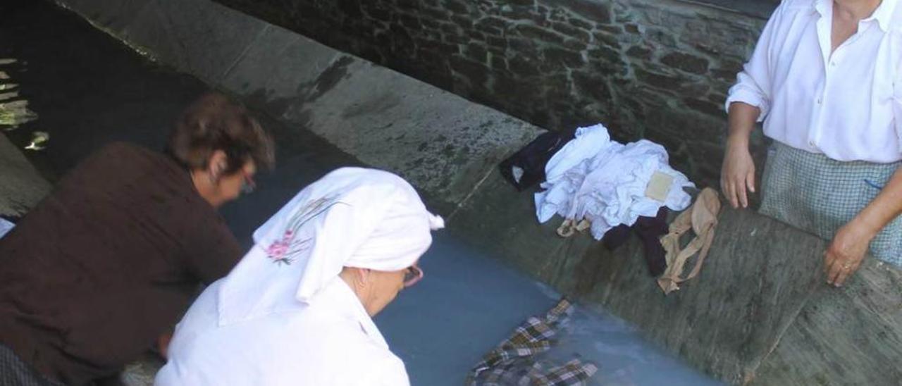 Mujeres lavando ropa, ayer, poco antes de descubrir la placa. a. m. serrano