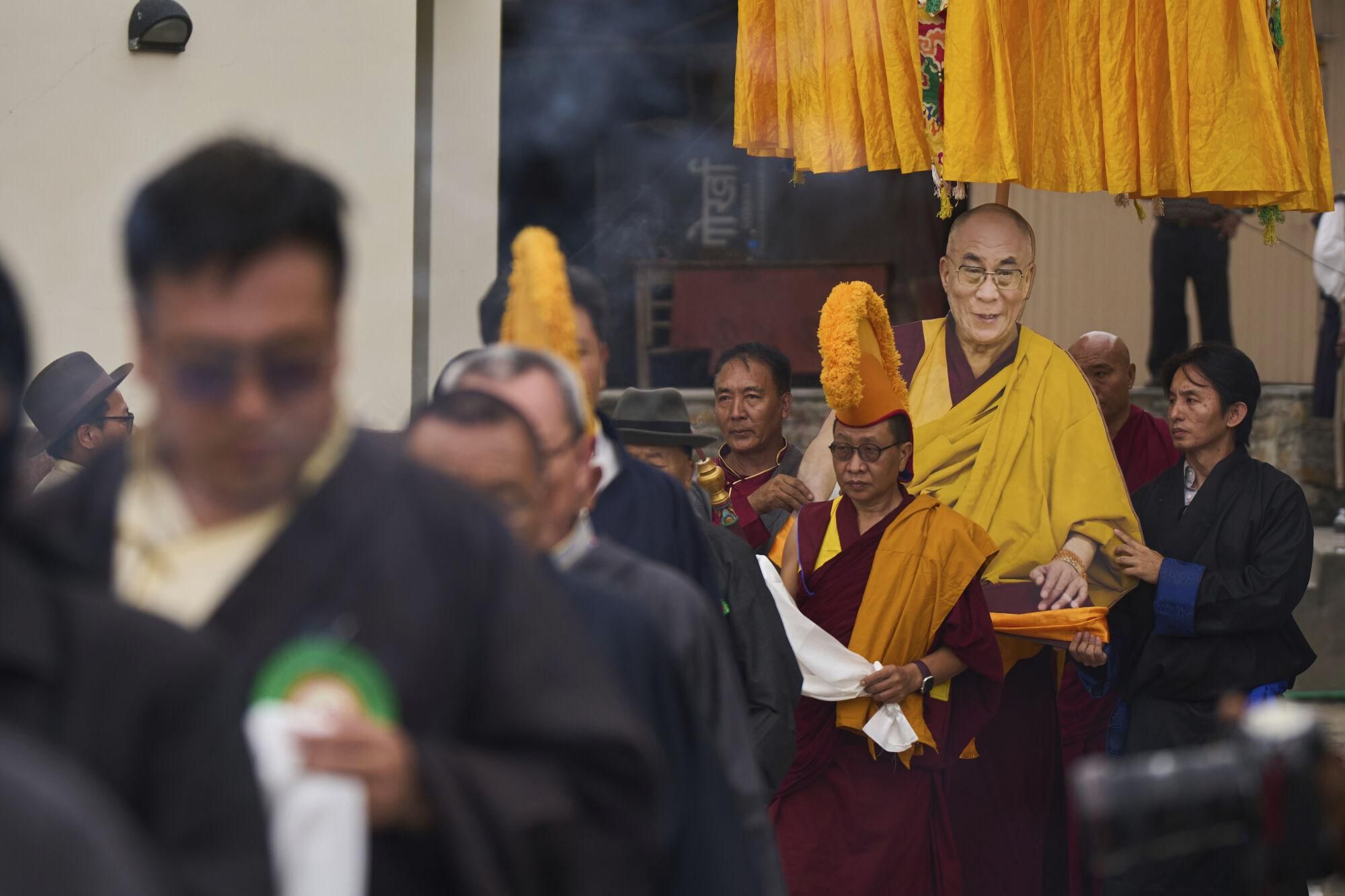 Tibetan men carry a portrait of their spiritual leader, the Dalai Lama, as community members gather to celebrate his 90th birthday at the Tibetan Camp in Kathmandu, Nepal, Sunday, July 6, 2025. (AP Photo/Niranjan Shrestha)