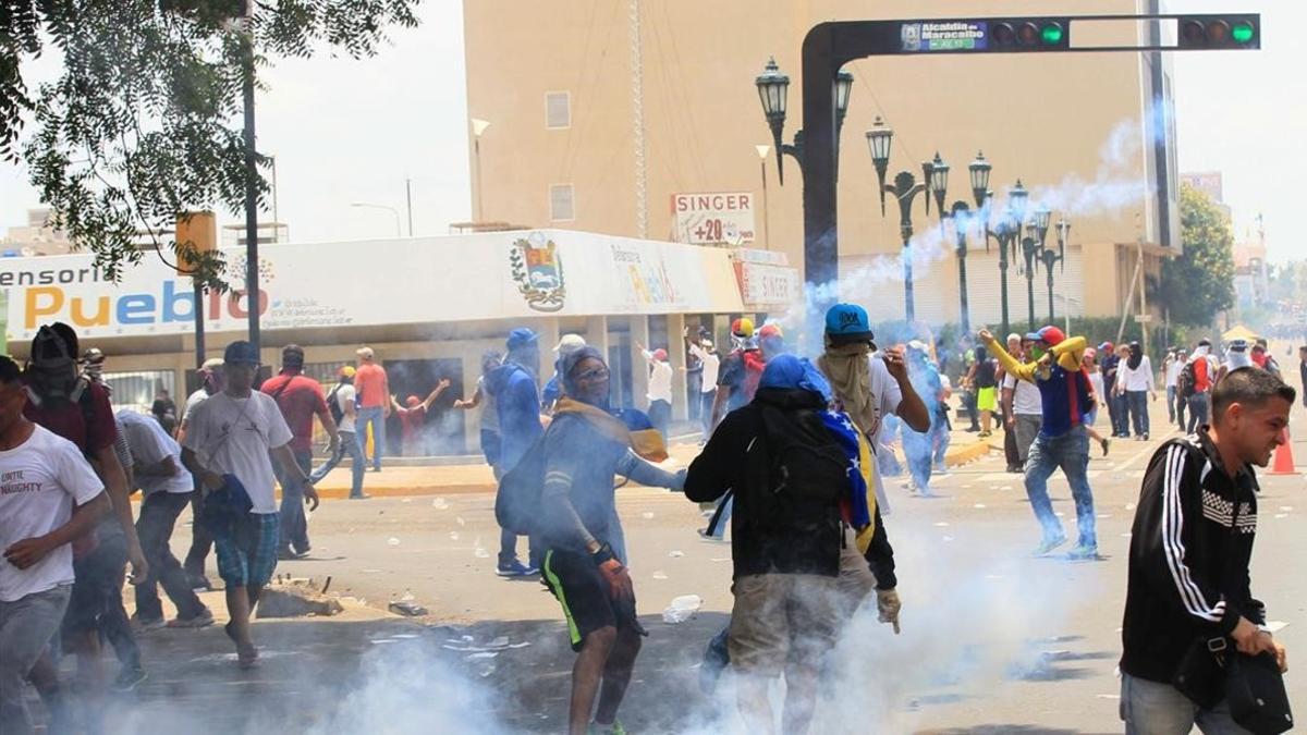 Seguidores de la oposición protestan contra el Gobierno de Maduro, en medio de gases lacrimógenos lanzados por las fuerzas de seguridad, en Maracaibo, el 19 de abril.