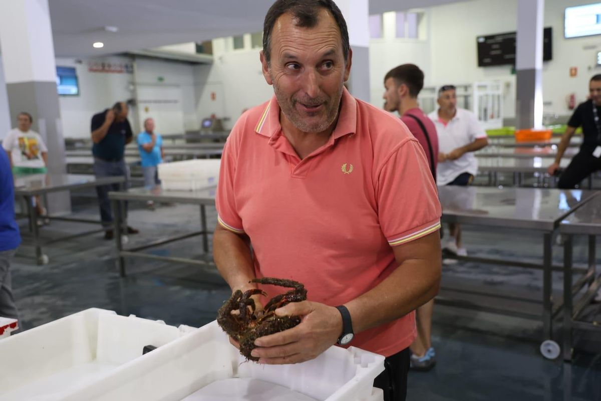 Un comprador grovense con un centollo en sus manos, ayer.