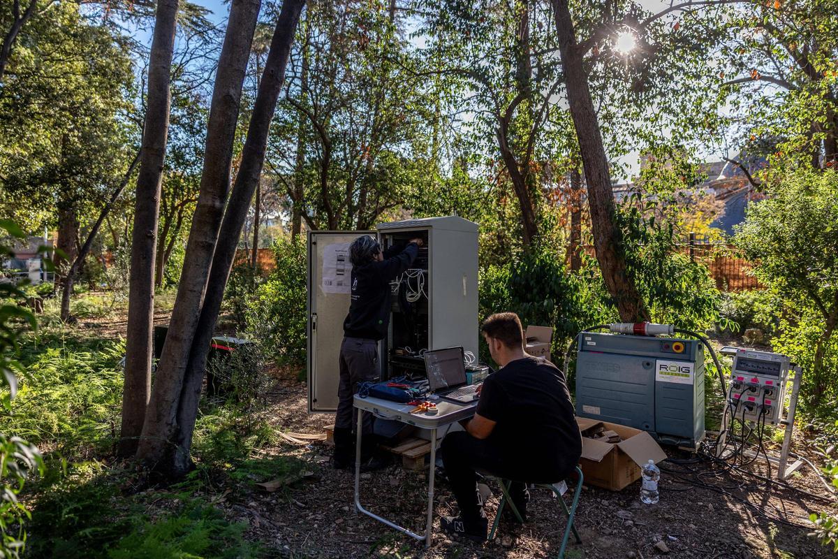 Unos técnicos preparando la instalación eléctrica de Natura Encesa, en el jardín de Torre Girona, en Barcelona.
