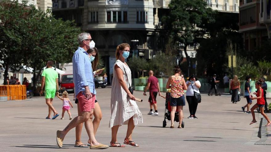 Varias personas paseando por la plaza peatonalizada del Ayuntamiento de València.