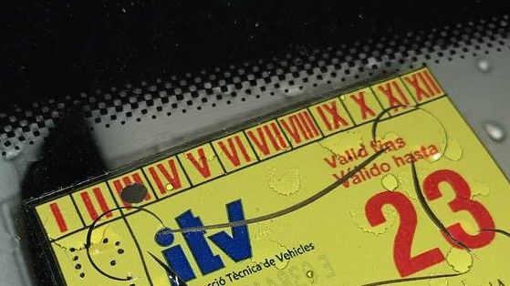 Una pegatina de la ITV en el parabrisas de un coche