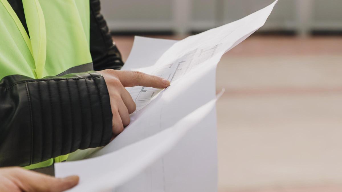 Operaris consulten un plànol d'obres, en una imatge d'arxiu.