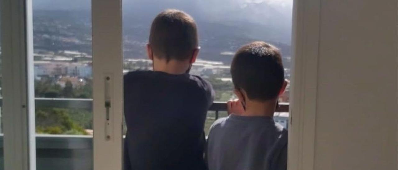 Dos niños en la ventana de una de las viviendas entregadas a los afectados por la erupción del volcán de La Palma