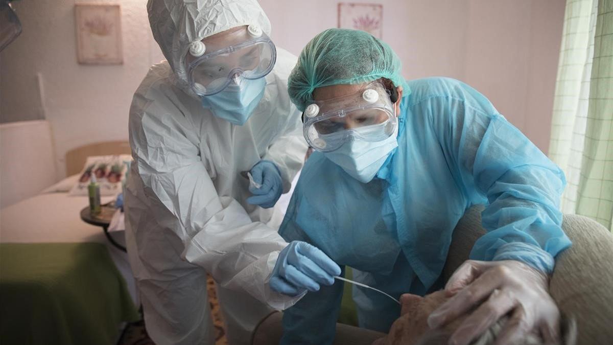 Dos enfermeras realizan pruebas de detección de coronavirus en una residencia geriátrica, el 14 de mayo del 2020