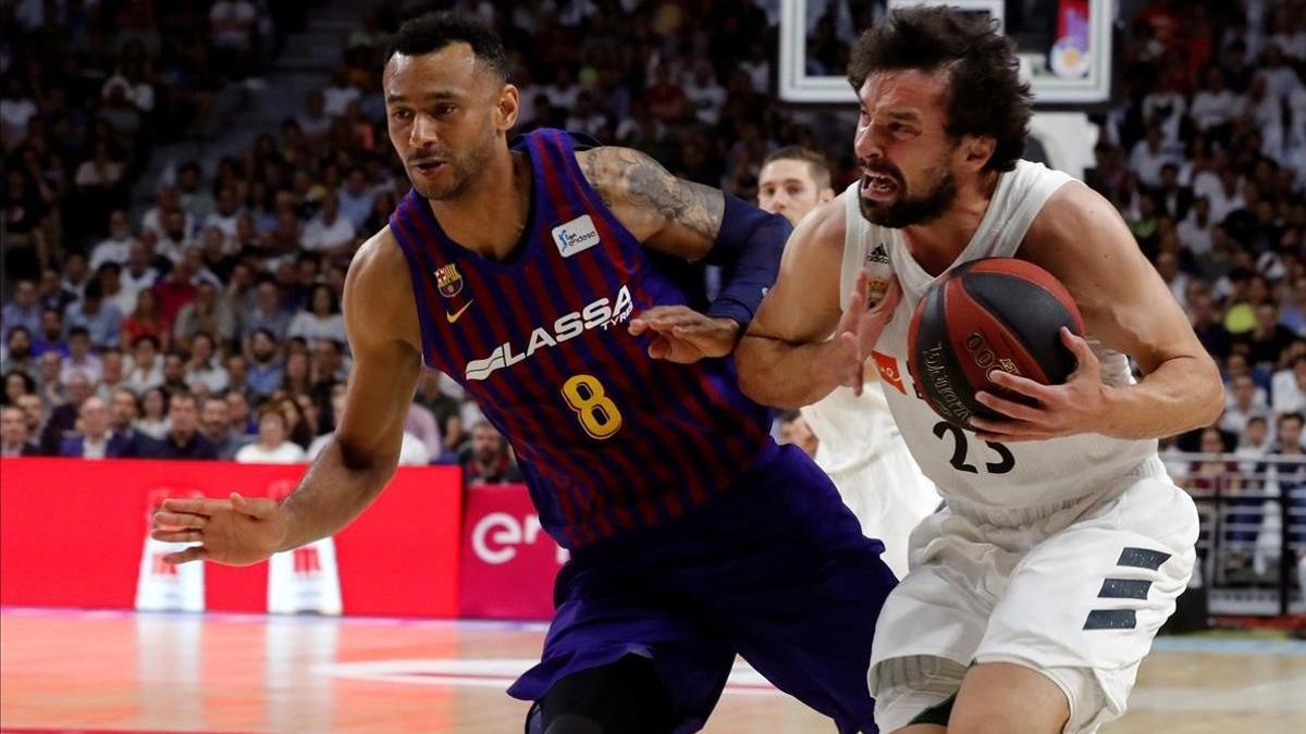 El base madridista Llull controla el balón presionado por la defensa de Hanga