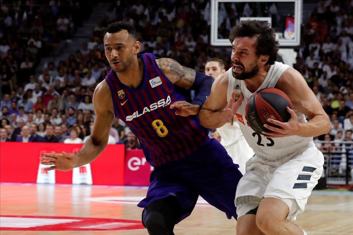 El base madridista Sergio Llull controla el balón presionado por la defensa de Adam Hanga.