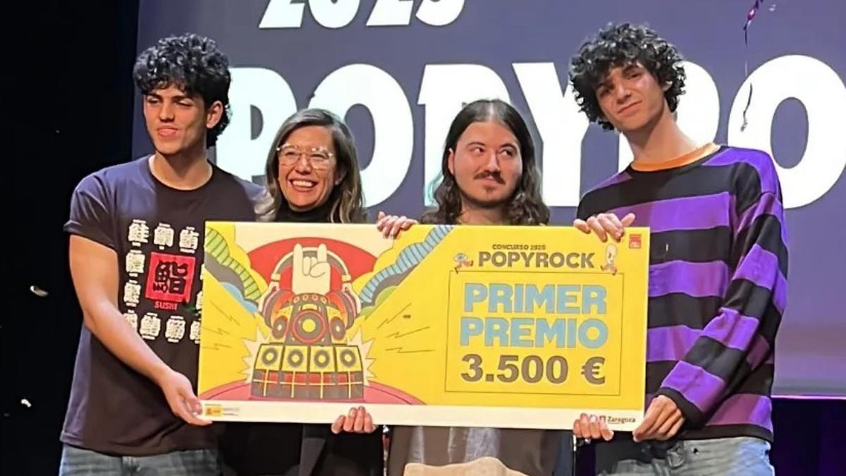 La banda vencedora, con la concejala Marián Orós, y su cheque como ganadores del Popyrock.