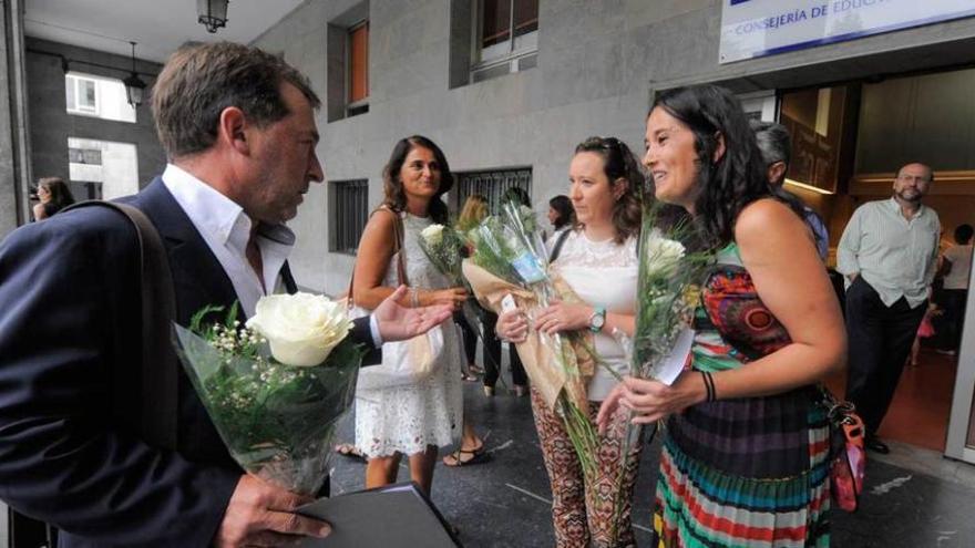 El consejero Genaro Alonso, a su llegada ayer al despacho, recibe flores de un grupo de orientadoras, sonrientes pero disconformes.