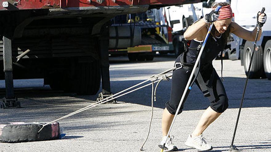 La alpinista Chus Lago, que tendrá que tirar de un trineo con 120 kilos en la Antártida, entrena arrastrando con arnés una rueda de camión de más de cincuenta kilos en O Porriño.