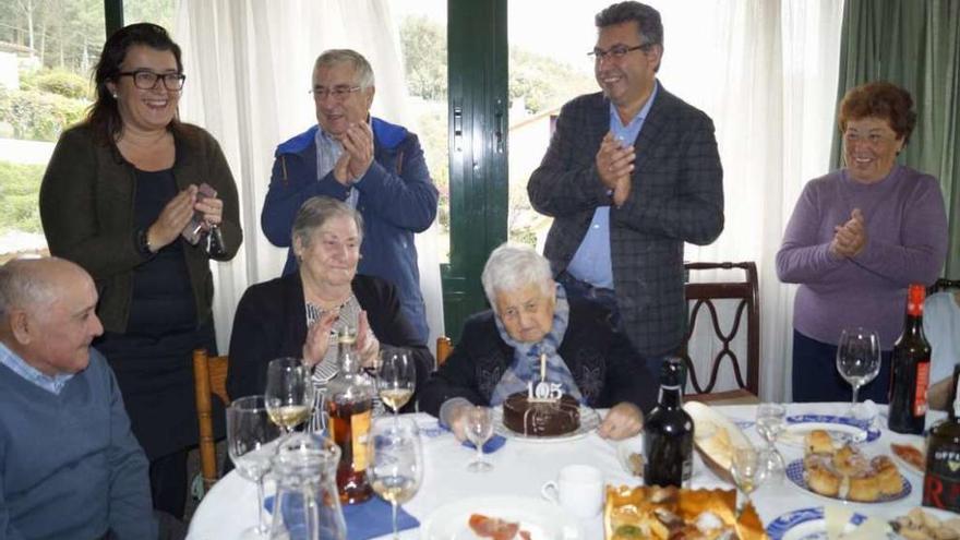 Ramona Cabaleiro sopla la vela de su tarta de cumpleaños, ayer, acompañado de sus familiares y por el alcalde, Javier Bas (2º por la derecha), y la edil de Benestar Social, María del Carmen Amoedo (izq). // FdV