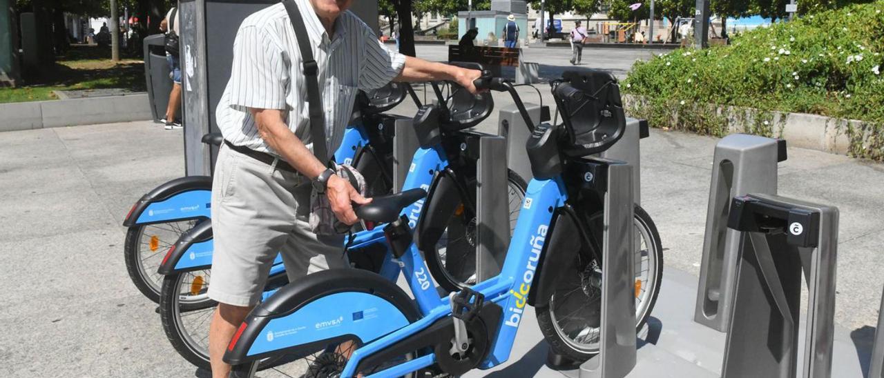 Xosé Iglesias, usuario de Bicicoruña, intenta retirar una bici en la plaza de Pontevedra.